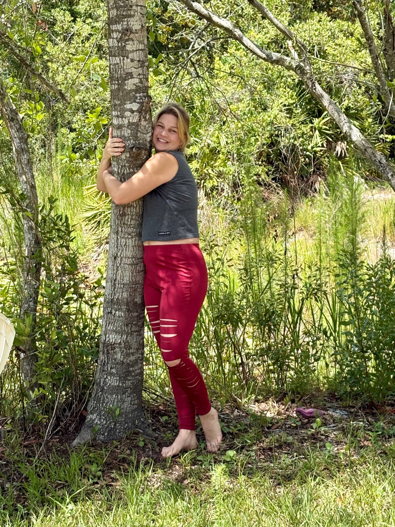 Dr. Verena Young embracing a tree in the Florida forest